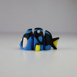 Blue and black 3D printed sensory fish toy with yellow fins on a white background.