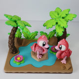 3D printed sensory toy with two pink flamingos, palm trees, and a pond on a colorful base