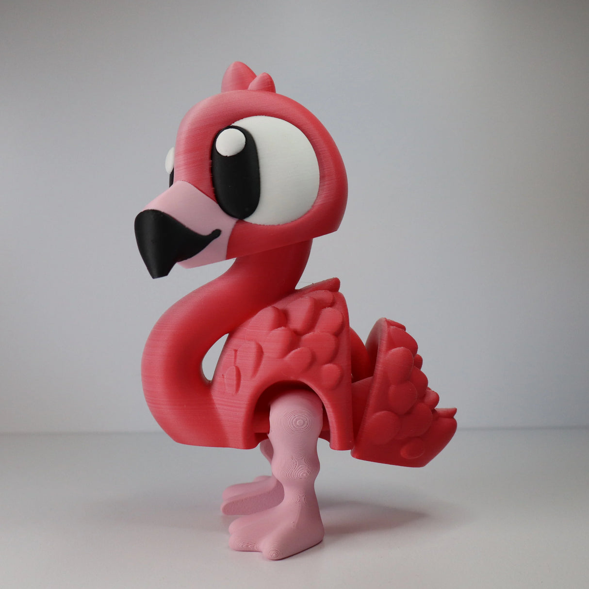 3D printed pink flamingo sensory toy with large eyes, designed for sensory-seeking kids