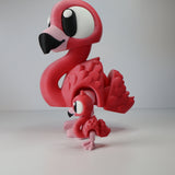 Two pink 3D printed flamingo sensory toys with movable wings and cartoon eyes