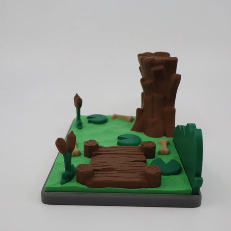 3D printed sensory toy with forest scene, logs, and bones for tactile play