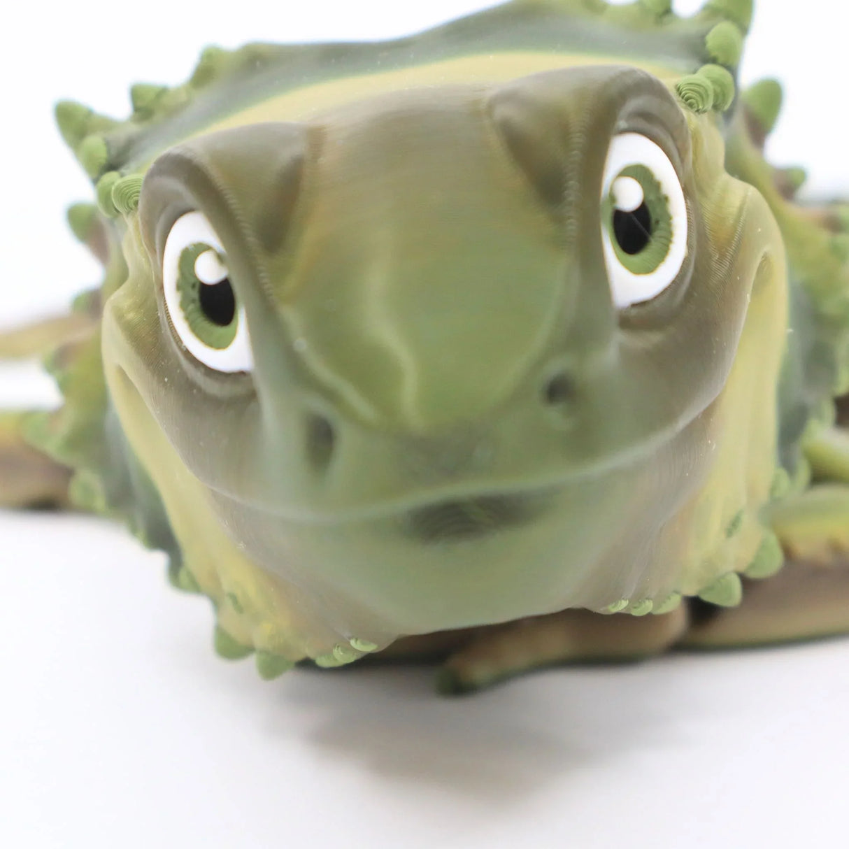 Close-up of a green 3D printed bearded dragon sensory toy with textured details
