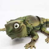 3D printed sensory toy lizard with green scales and jointed limbs on white background