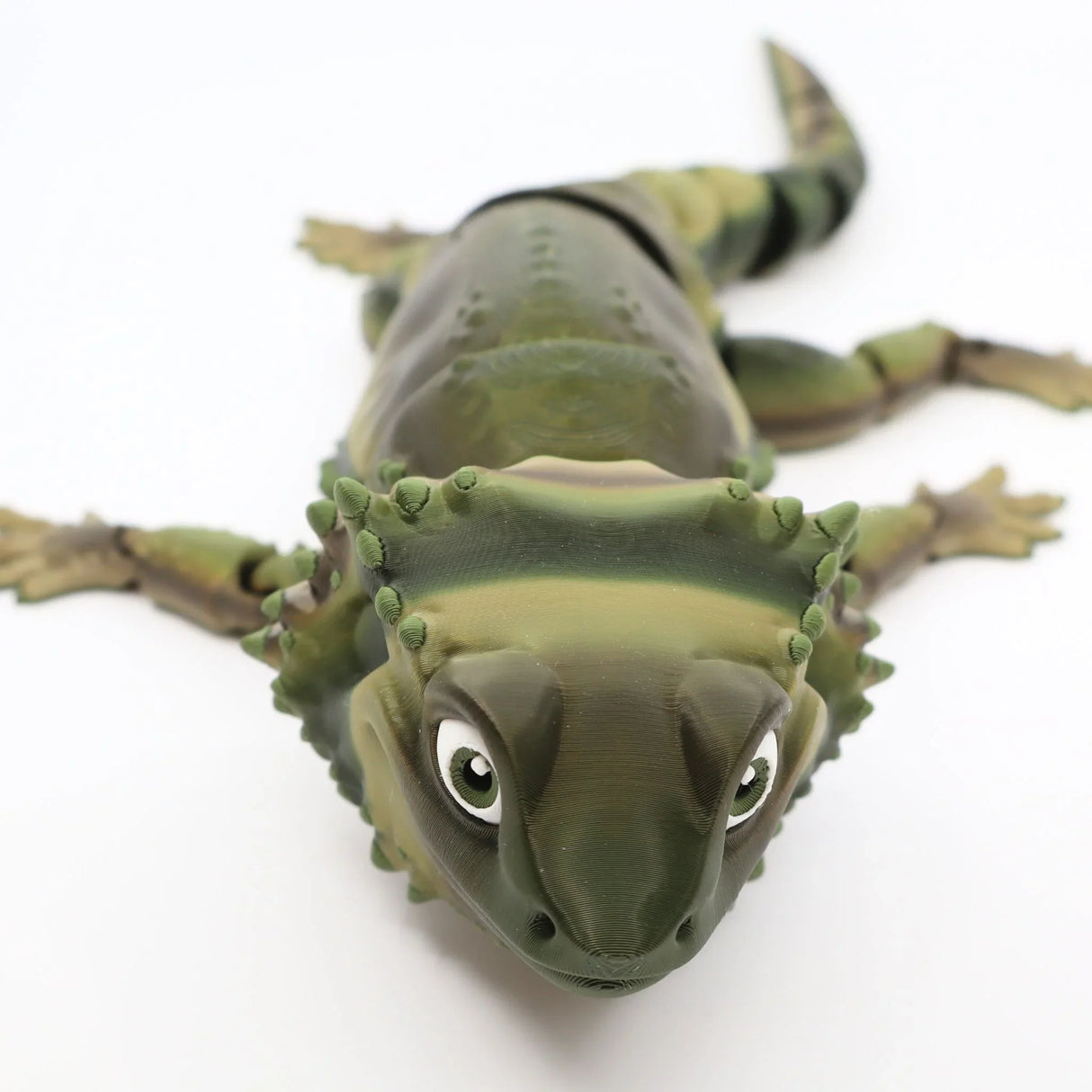 3D printed flexible bearded dragon sensory toy with green stripes on white background