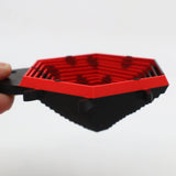 Red and black hexagonal 3D printed sensory toy with geometric layers, held by hand