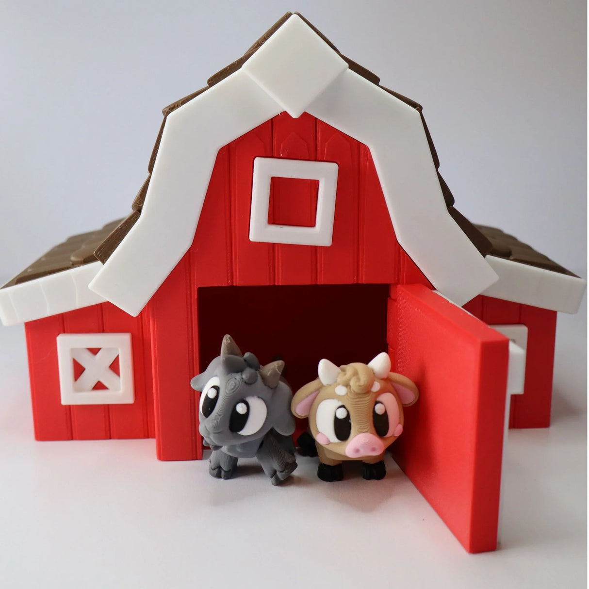3D printed red toy barn with cute sensory goat and cow figures at the entrance