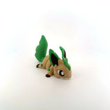 3D printed sensory toy of a cute green and brown animal with leaf-shaped tail on white background