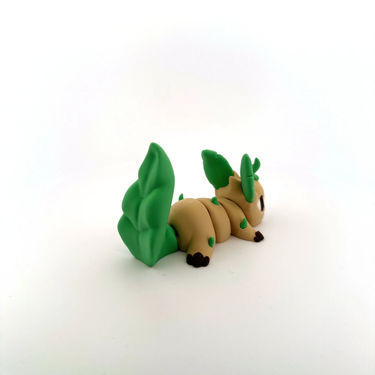 3D printed sensory toy shaped like a tan and green fantasy animal with leaf-like tail