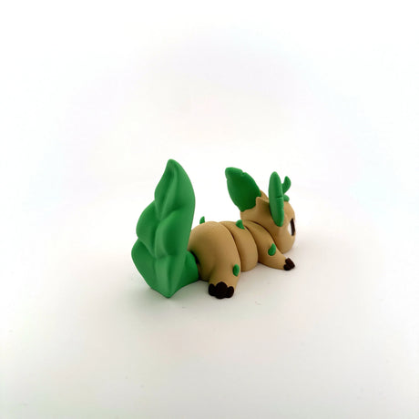 3D printed sensory toy shaped like a tan and green fantasy animal with leaf-like tail