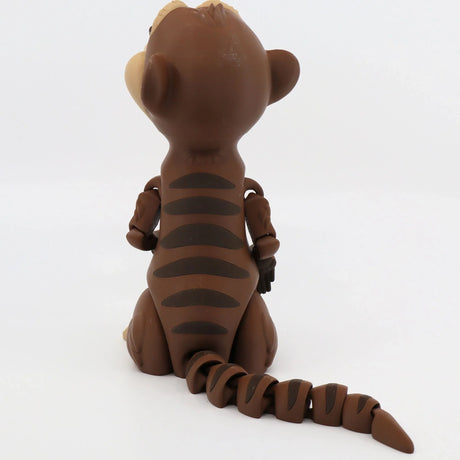 Back view of brown 3D printed meerkat sensory toy with striped tail on white background