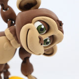 3D printed monkey sensory toy with movable limbs and green eyes on a white background