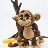 3D printed brown monkey sensory toy with flexible joints, tree, and banana, on white background