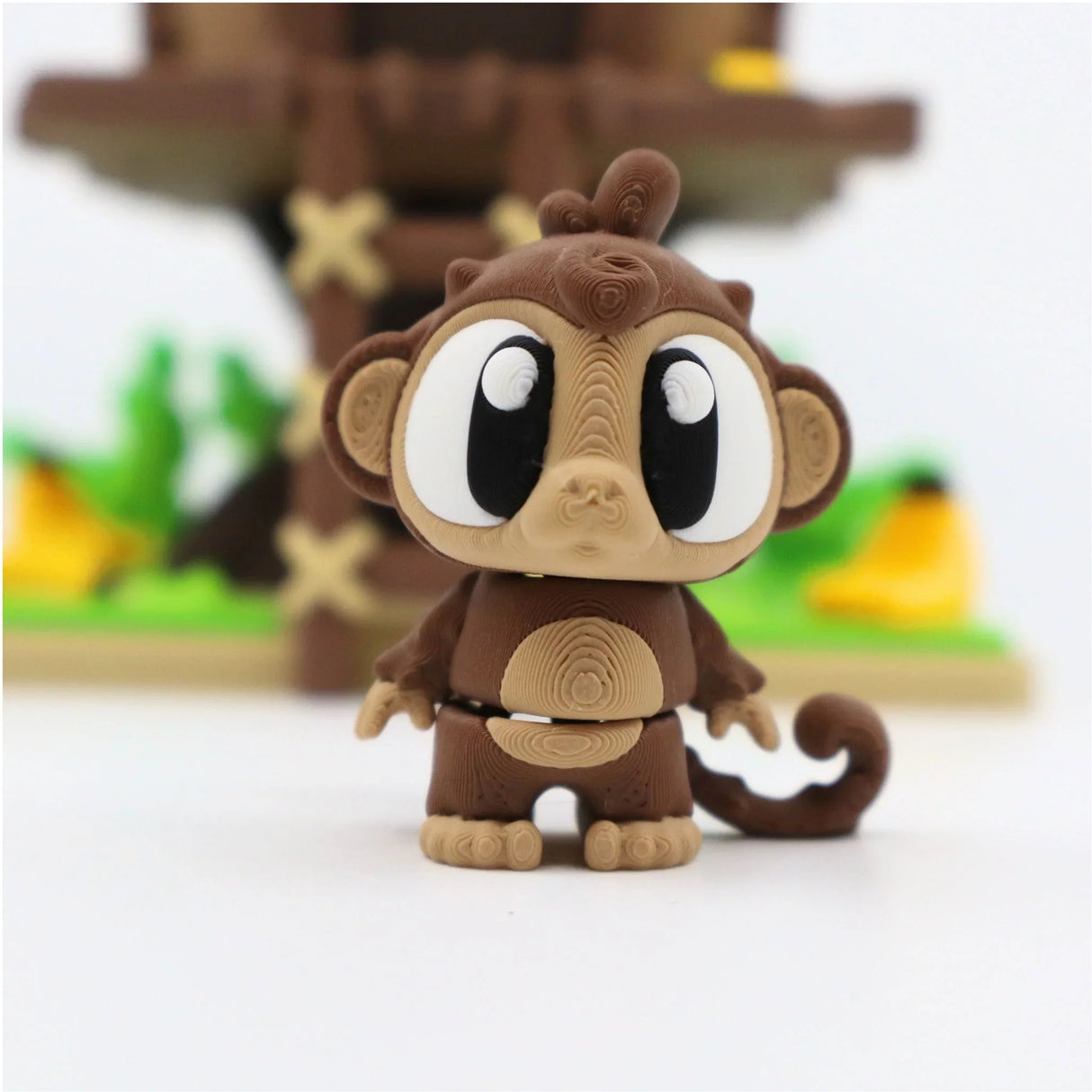 3D printed sensory monkey toy with big eyes, standing in front of a colorful playset
