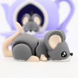 Cute 3D printed gray mouse sensory toy with a purple teapot in the background