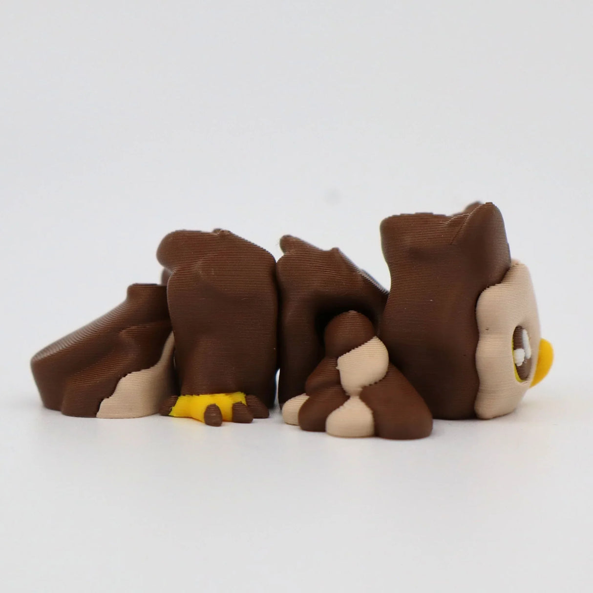 Brown 3D printed sensory owl toy with yellow beak and feet, shown on white background