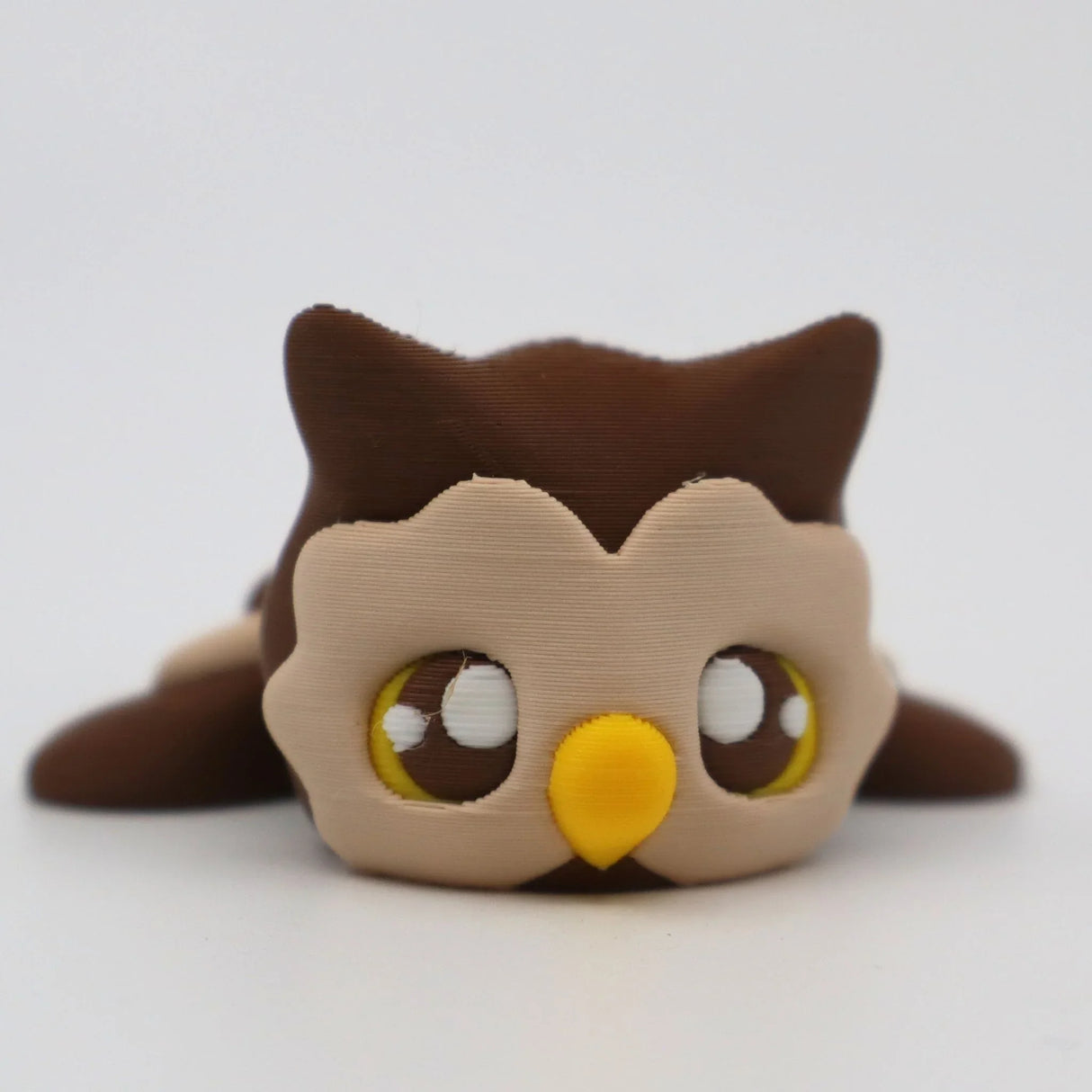 Cute brown 3D printed owl sensory toy with big eyes and a yellow beak on white background