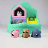 Colorful 3D printed sensory animal toys in front of a soft green play yard set.
