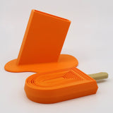 Orange 3D printed popsicle-shaped sensory toy with matching stand on white background.