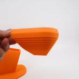 Hand holding an orange 3D printed sensory popsicle toy with textured ridges