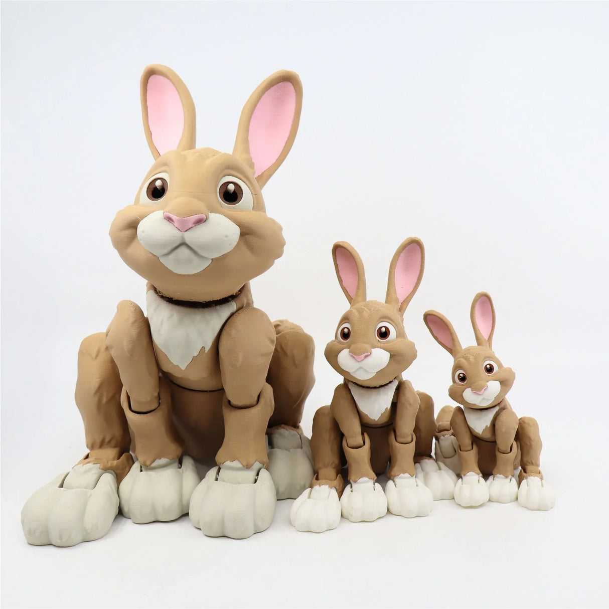 Set of three brown 3D printed sensory toy rabbits with articulated legs, white paws, and pink ears