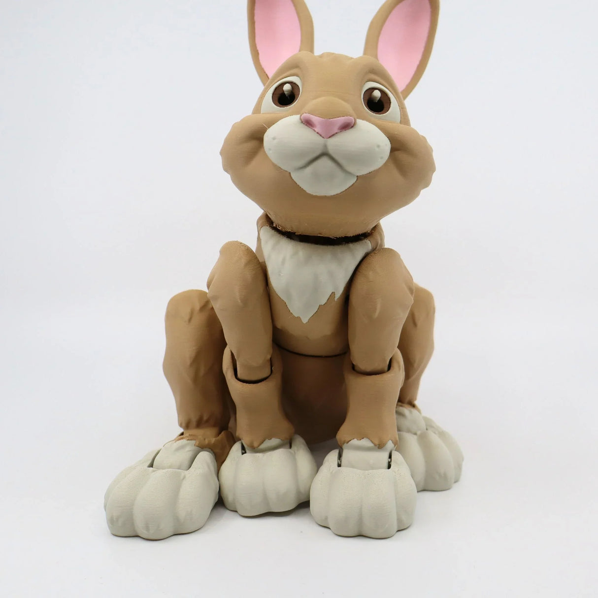 3D printed sensory rabbit toy with jointed limbs, brown body, white paws, and pink ears.