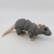Gray 3D printed sensory rat toy with jointed segments and beige feet, on white background.