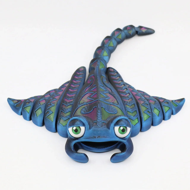 Colorful 3D printed ray-shaped sensory toy with green eyes and detailed patterns on wings.