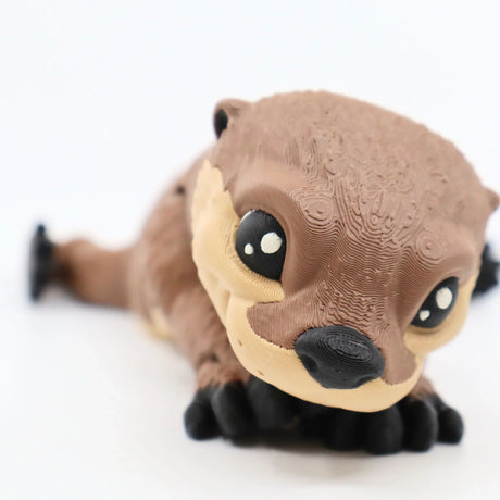 Cute 3D printed sea otter sensory toy with textured surface on white background