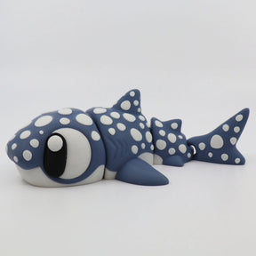 Blue and white 3D printed shark sensory toy with spots, jointed body, and large eyes on white background.
