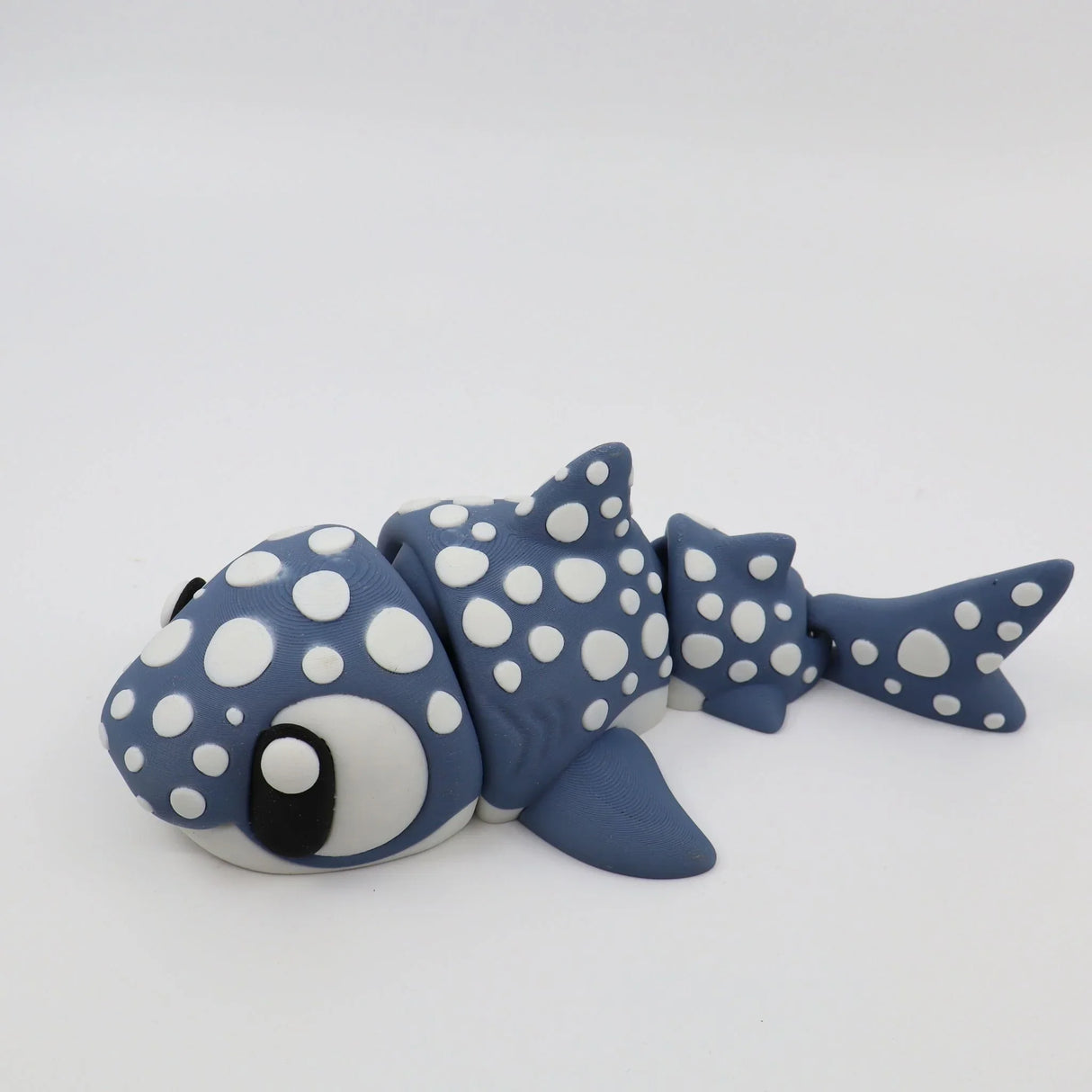 Blue and white 3D printed shark sensory toy with flexible segments on a white background