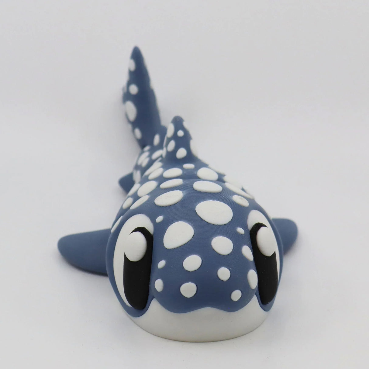 Blue and white 3D printed whale shark sensory toy with large eyes on a white background