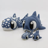 Set of four blue shark and whale shark sensory toys with large eyes on white background