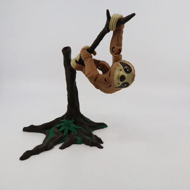3D printed sloth sensory toy hanging from a tree branch with movable joints.