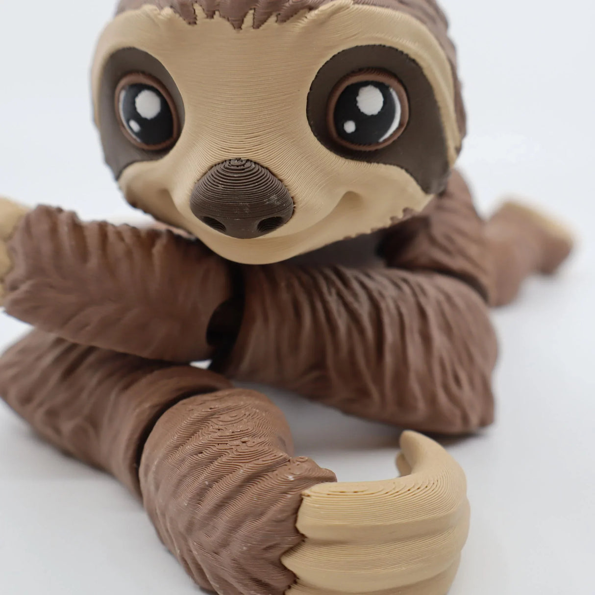 3D printed brown sloth sensory toy with flexible limbs and large eyes on white background