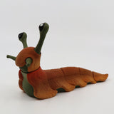 3D printed orange and green sensory slug fidget toy with moveable segments on white background