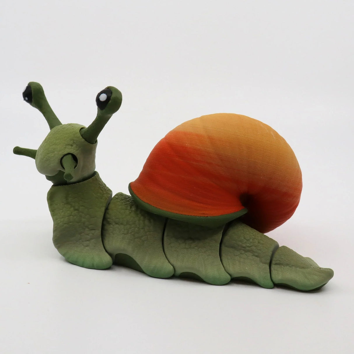 3D printed sensory snail toy with green body and orange shell on white background