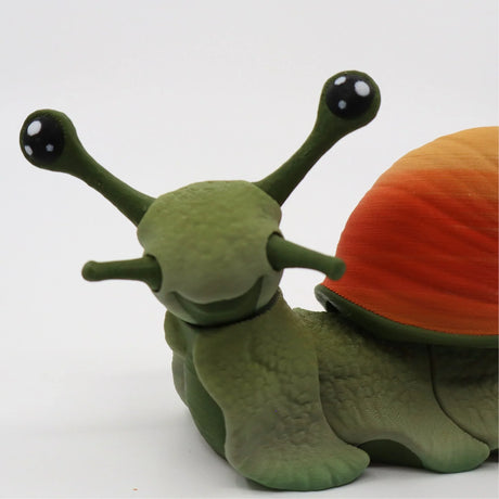 3D printed sensory snail toy with green body and orange shell on white background