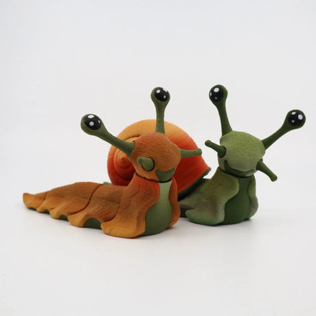 Colorful 3D printed snail sensory toys with large eyes and textured shells on white background