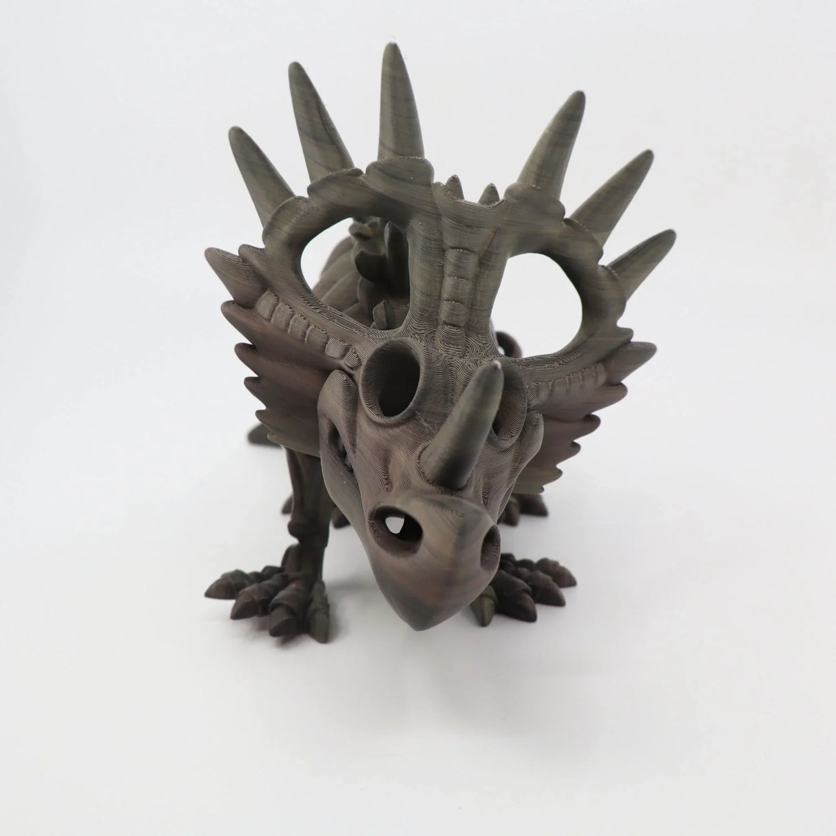 3D printed Styracosaurus dinosaur sensory toy with textured brown finish on white background