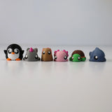 Colorful 3D printed animal sensory toys arranged in a row on a white surface.