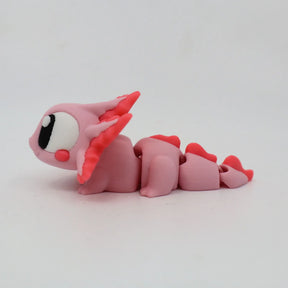 Pink 3D printed axolotl sensory toy with segmented body and large eyes on white background