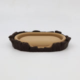 3D printed sensory toy resembling a miniature brown and beige animal bed with textured edges.