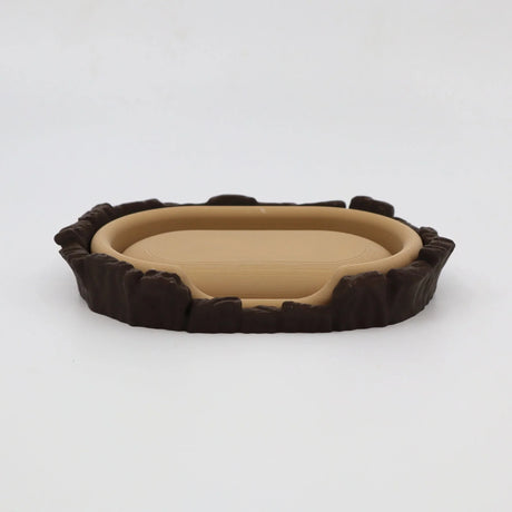 3D printed sensory toy resembling a miniature brown and beige animal bed with textured edges.