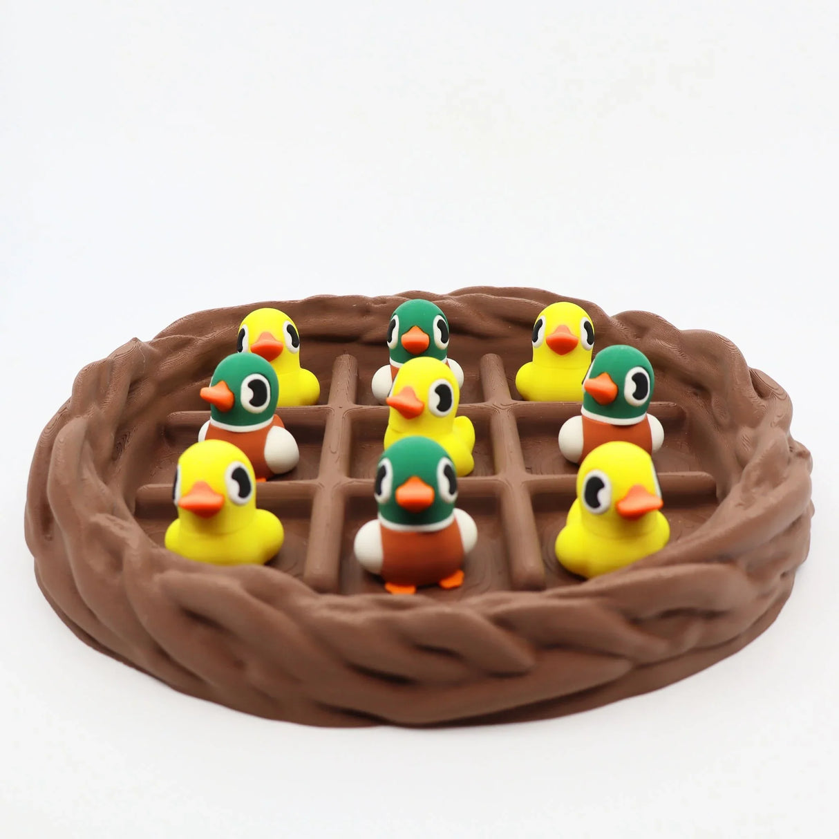 Colorful 3D printed duck sensory toys in a brown nest, perfect for fidgeting and sorting activities.