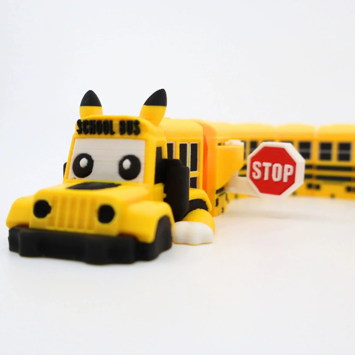 Cute 3D printed yellow school bus fidget toy with stop sign, perfect for sensory play and kids' education.
