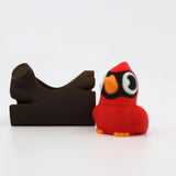 Red cardinal fidget toy with orange beak and feet beside brown 3D printed sensory block