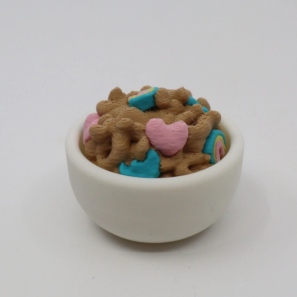 3D printed sensory toy shaped like cereal in a white bowl with colorful heart pieces