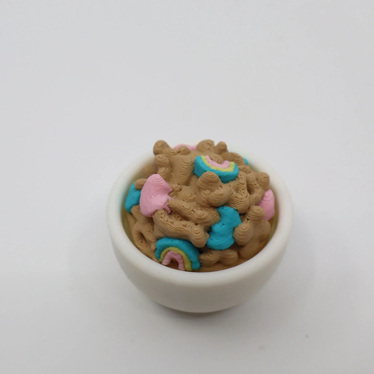 3D printed sensory cereal toy in a white bowl with colorful blue and pink details