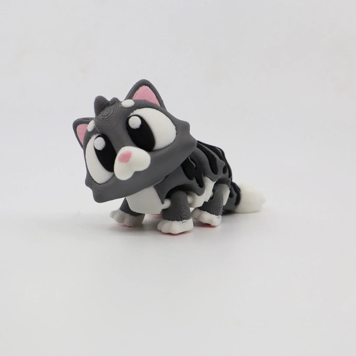 3D printed grey cat sensory toy with big eyes on a white background