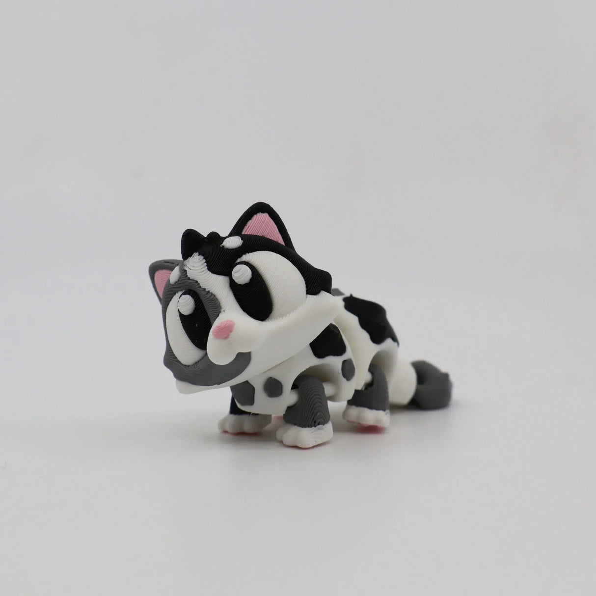 3D printed black and white cat sensory toy with large eyes and flexible joints